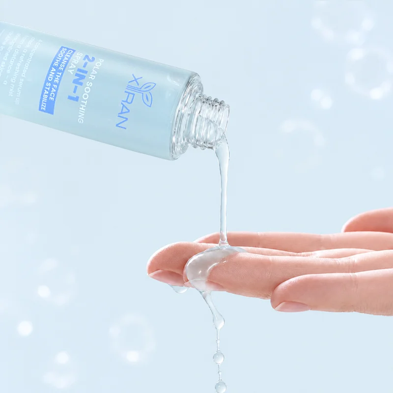 A clear skincare serum being poured from a light blue bottle onto a person's fingers against a soft blue background.